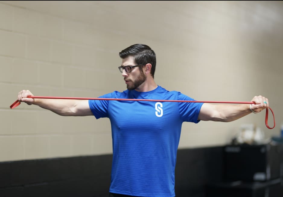 A man holding onto a red resistance band