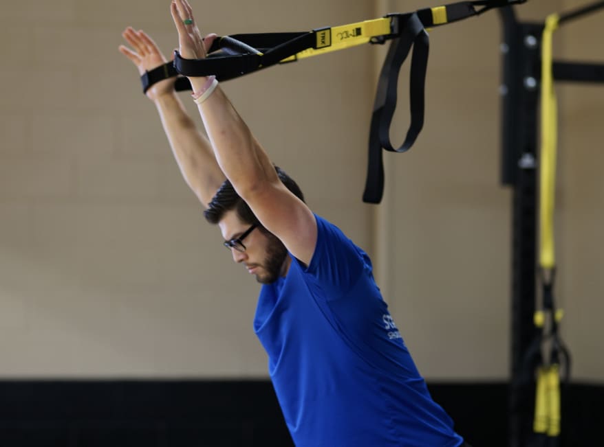 A man is doing some gymnastics on the trx.