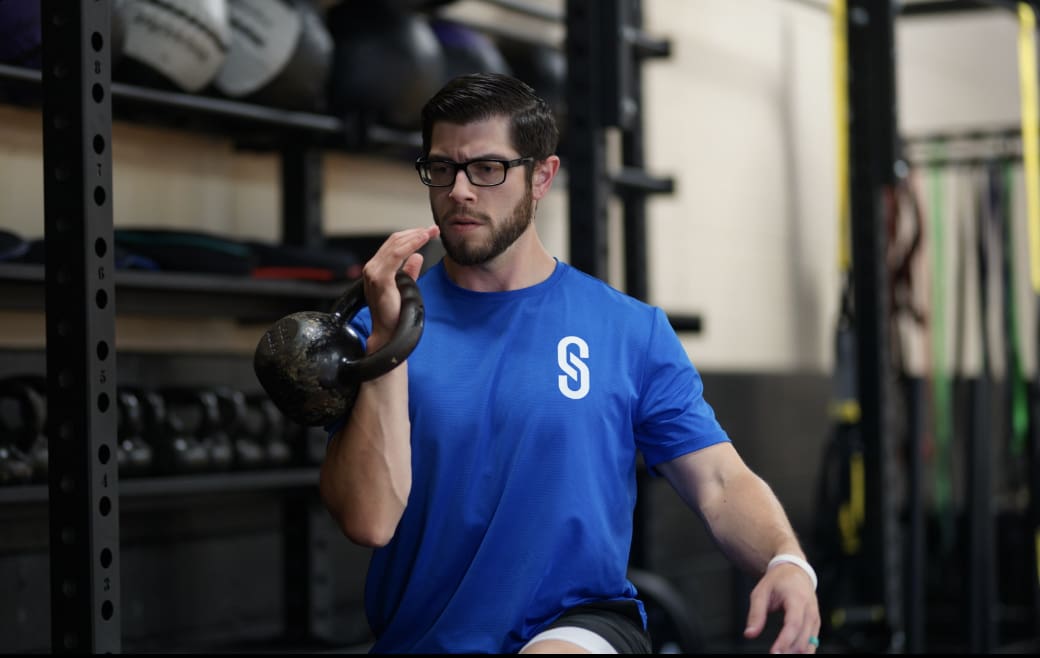 A man holding a kettlebell in his hand.